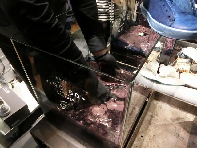 画像: レザーを水につけて絞り、藍色に染める液が染み込みやすくする。そのあと、藍色に染める液体につける