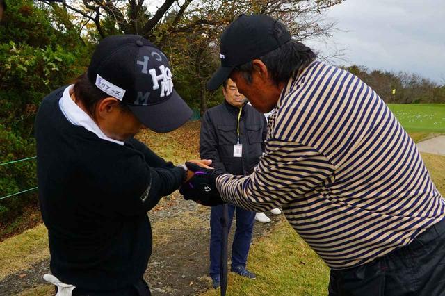 画像: 右手の使い方を藤本佳則の手を取って指導するジャンボ尾崎