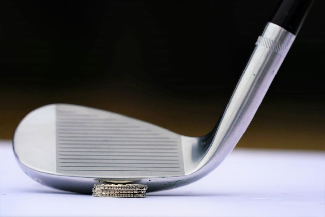 画像: バウンス14度のウェッジは、ショップの床に置くとコイン3枚分ほどリーディングエッジが浮いてしまう。しかし、ここまで説明した通り、それは「やさしさ」の証なのだ