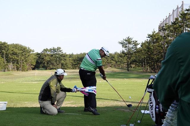 画像: 右足をタオルで引っ張りながらボールを打つ松山