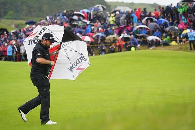 画像: 傘を横に差すほどの強い雨風が選手たちを襲う