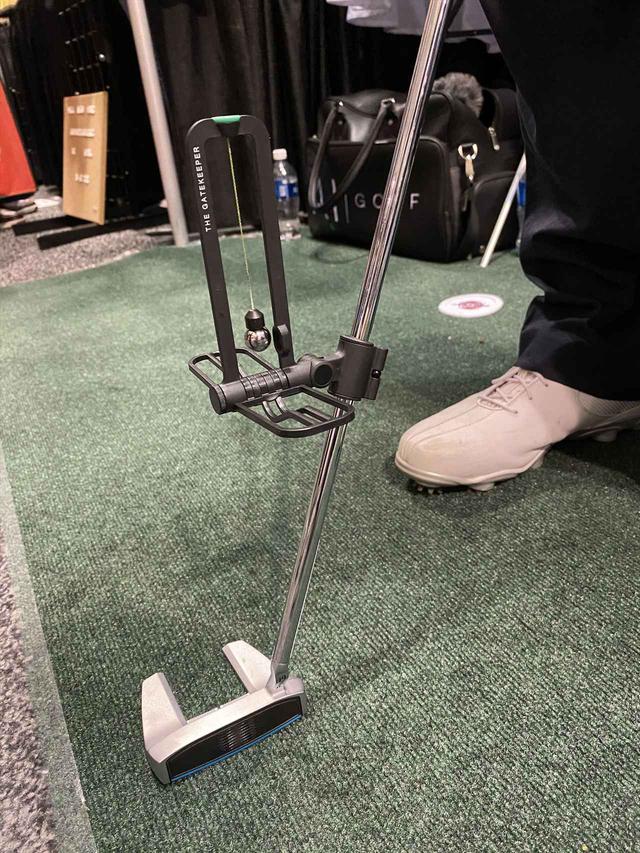 画像: パターに取り付け、ひもでぶら下げた鉄球が暴れないように振るための器具。かなりアナログですが実際にやってみると難しい! 効果もありそうでした
