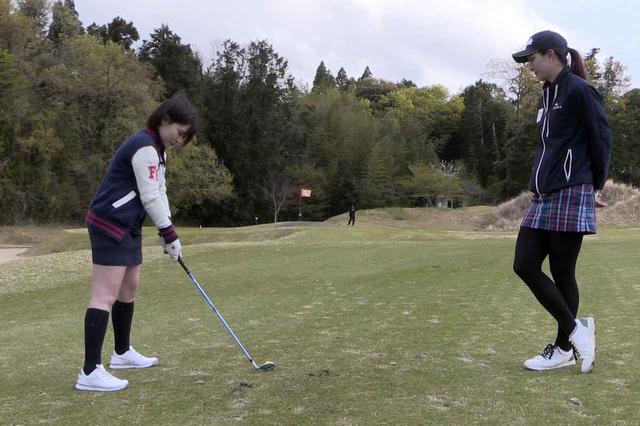 画像: 苦手なハーフショットのアプローチを克服すべく、高島の指導を受ける飯田