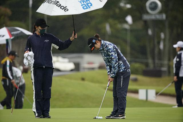 画像: 雨の中、藤田は大西に傘をさしかける(写真は富士通レディース2020 写真/大澤進二)