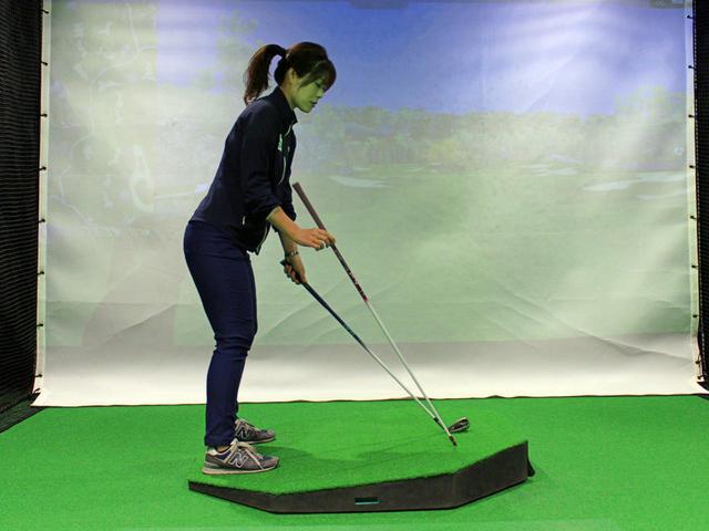 画像: つま先上がりでは、スウィングプレーンが平坦なライで打つ場合(大谷が右手で持っているシャフトで示したライン)よりもフラットになるという