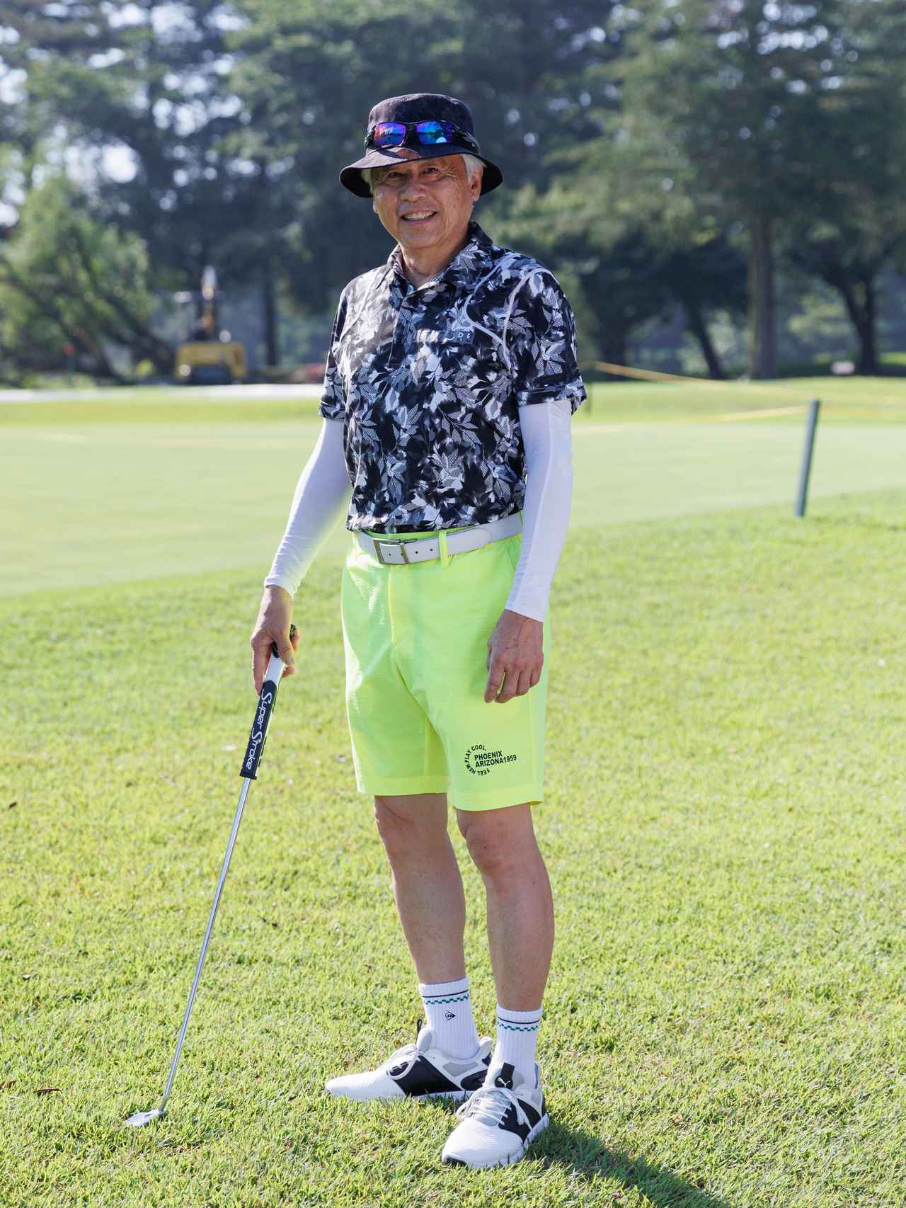 画像: モノトーンのアスリート感漂うボタニカル柄ポロに鮮烈なイエローのショートパンツ。シックな色合いのハットもトップスと好相性で、絶妙なカジュアルさをプラスしてくれます