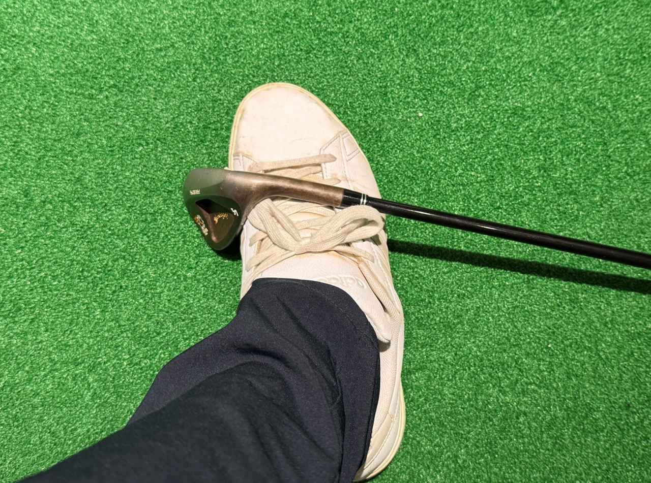 画像: 右足の甲にクラブを乗せ、落ちないようにベタ足でボールを打つ