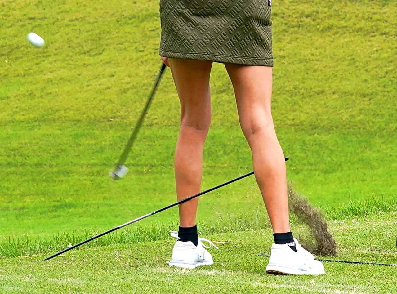 画像: アライメントスティックを両脚に挟んでショット練習する原英莉花