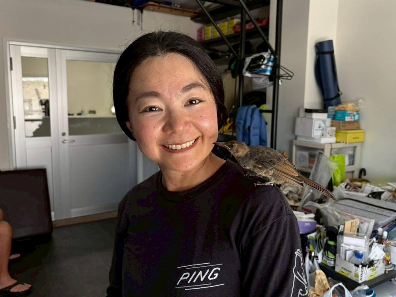画像: ヒヨドリとたわむれる彩子。満面の笑みを浮かべる。「姉の事務所兼トレーニング場所です。肩に乗っているのがピーちゃんです。かわいいでしょ」