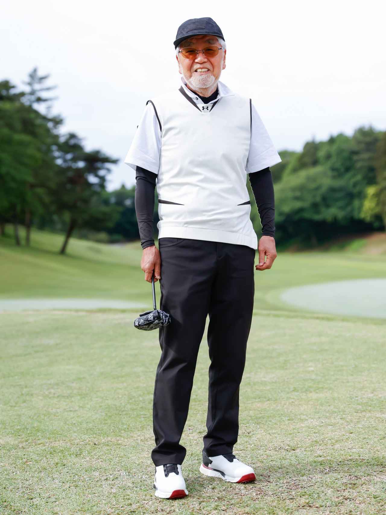 画像: 黒のモックネックに白のポロとVネックベストの組み合わせが新鮮でモダンなトップスレイヤード。そこにアウトドアテイストのキャップも加えることで今っぽさも漂います