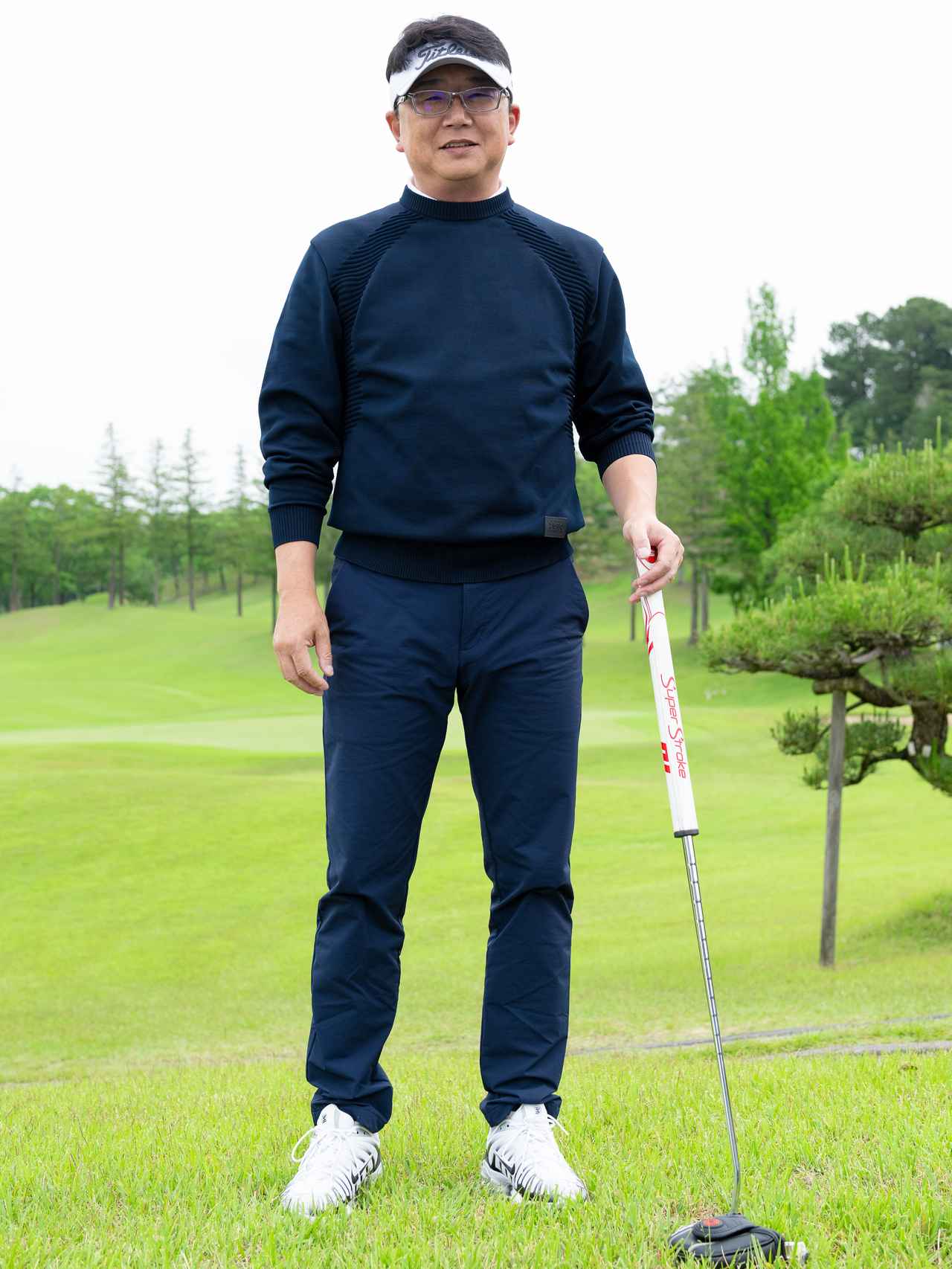 画像: シンプル&エレガントな王道ネイビーのニットセーターとパンツの組み合わせ。インナーやサンバイザー、シューズをホワイトにすることで重くならないトーンに仕上げています