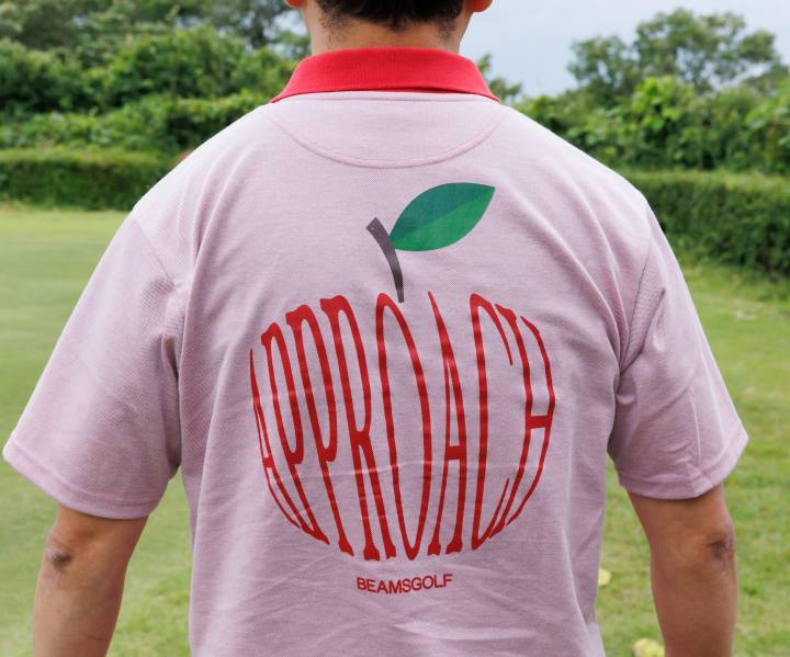 画像: 背中にアップルモチーフの「APPROACH」の文字が描かれたポロ