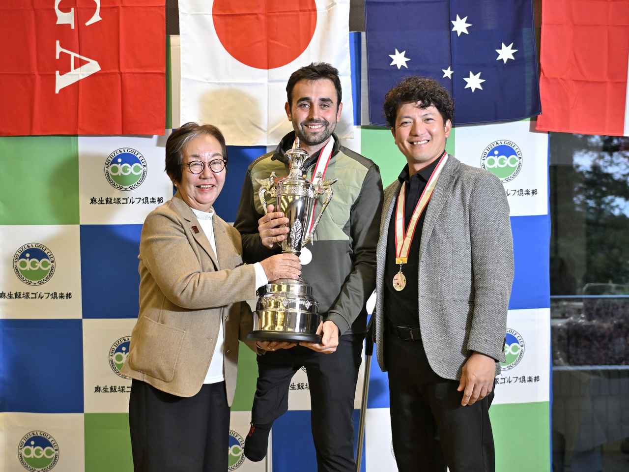 画像: DGA代表理事の松田治子氏と優勝したポスティゴ、2位の吉田。出場選手たちの国旗の下で、再び世界のどこかで戦うことを約束して!