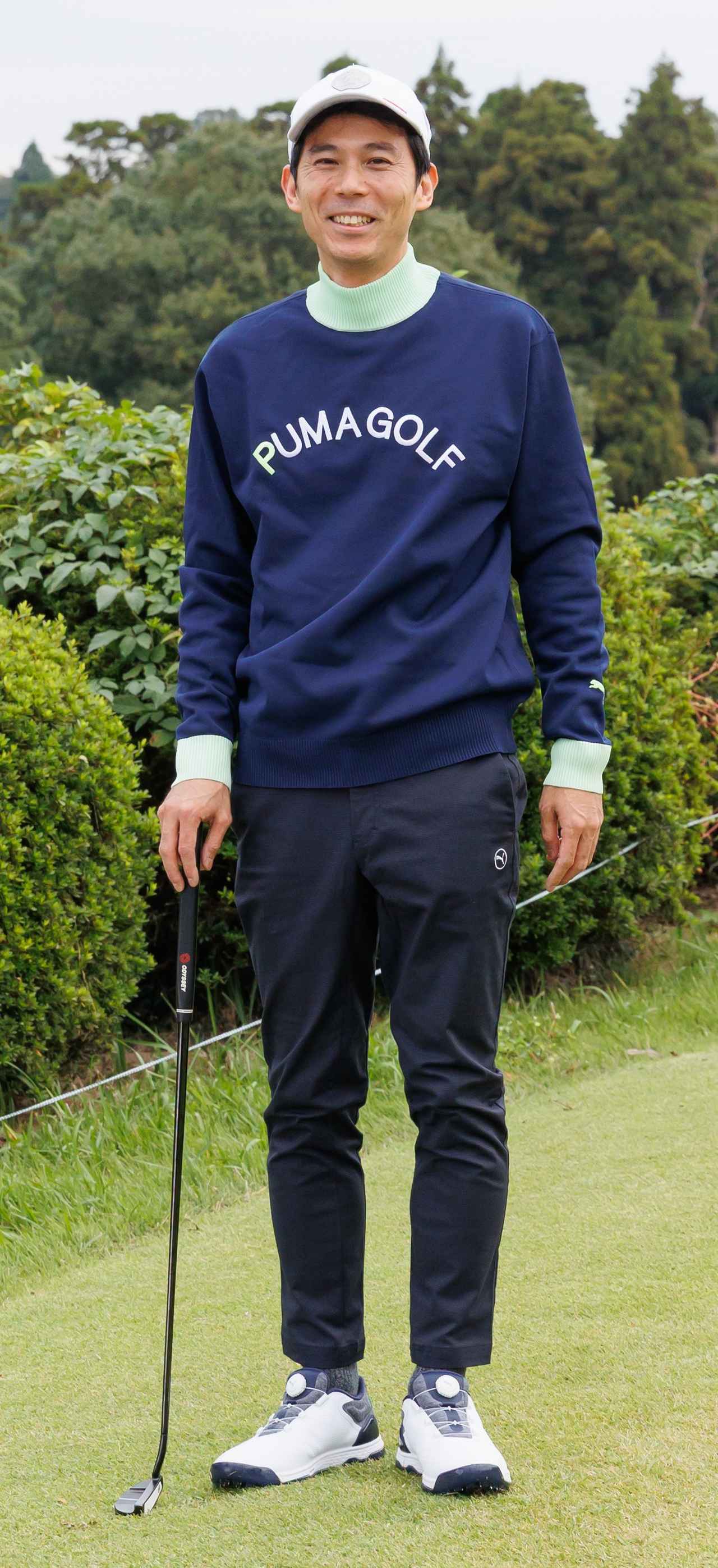 画像: ネイビーのボディがベースながら、ネックと袖口部分にライムグリーンを差し色としたハイネックセーターが主役。ダークトーンのパンツがトップスをより引き立てています