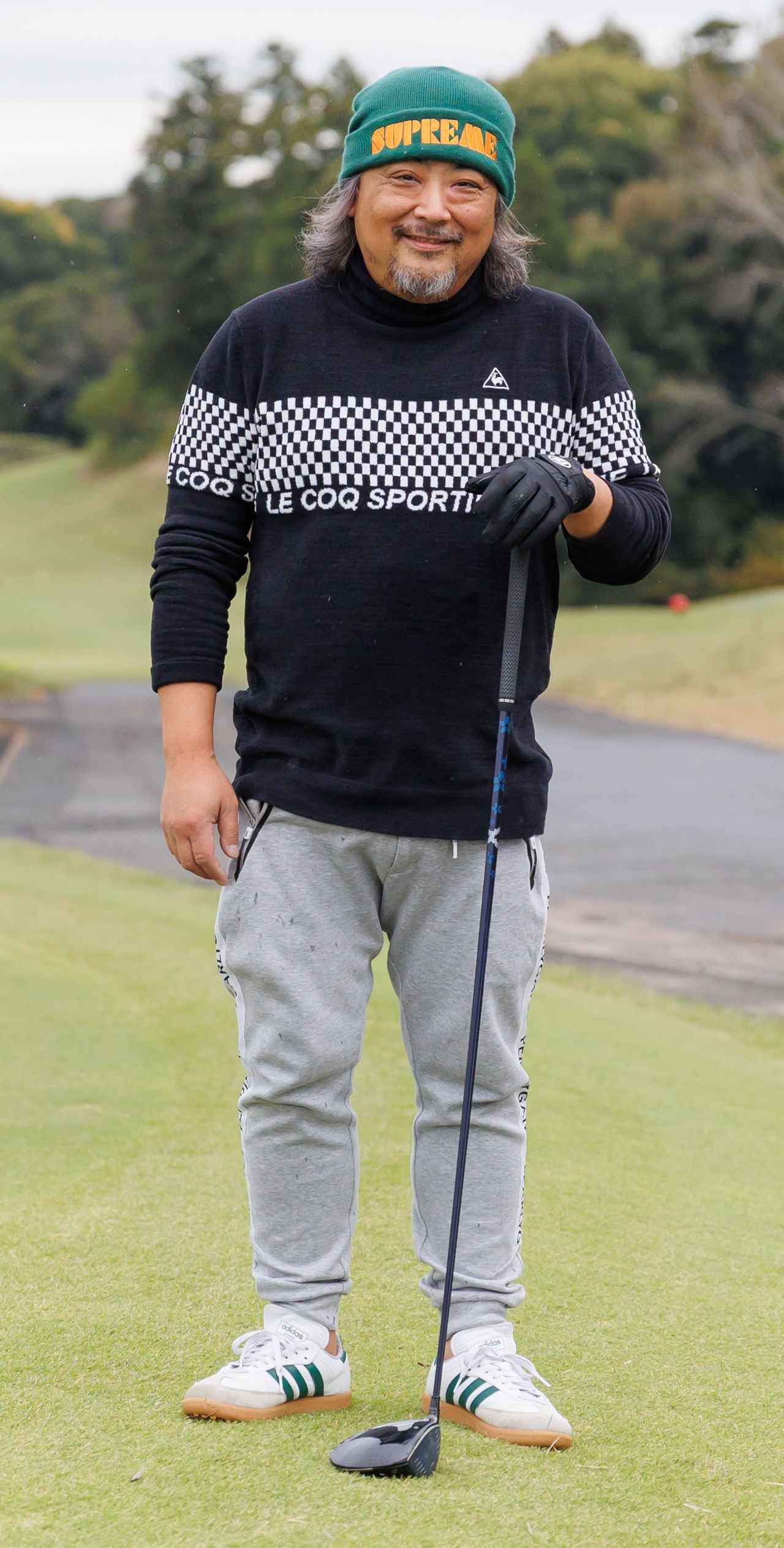 画像: チェッカーフラッグ柄を配したハイネックセーターにスウェットライクなグレーパンツが好相性。ストリートブランド、シュプリームのグリーンビーニーにも遊び心を感じさせます