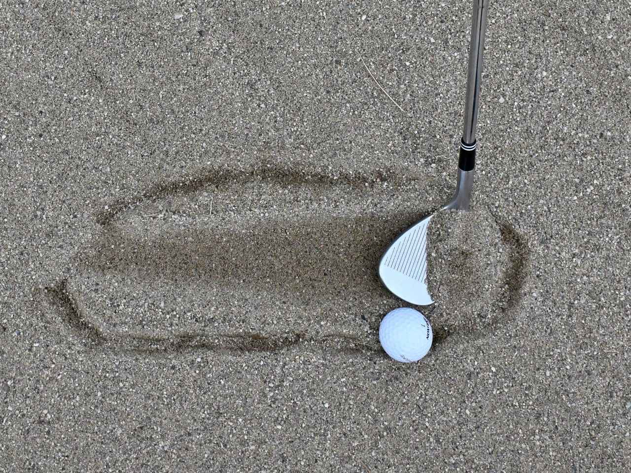 画像: ボールのかなり手前から緩やかにヘッドを入れ、薄く長く砂を取る