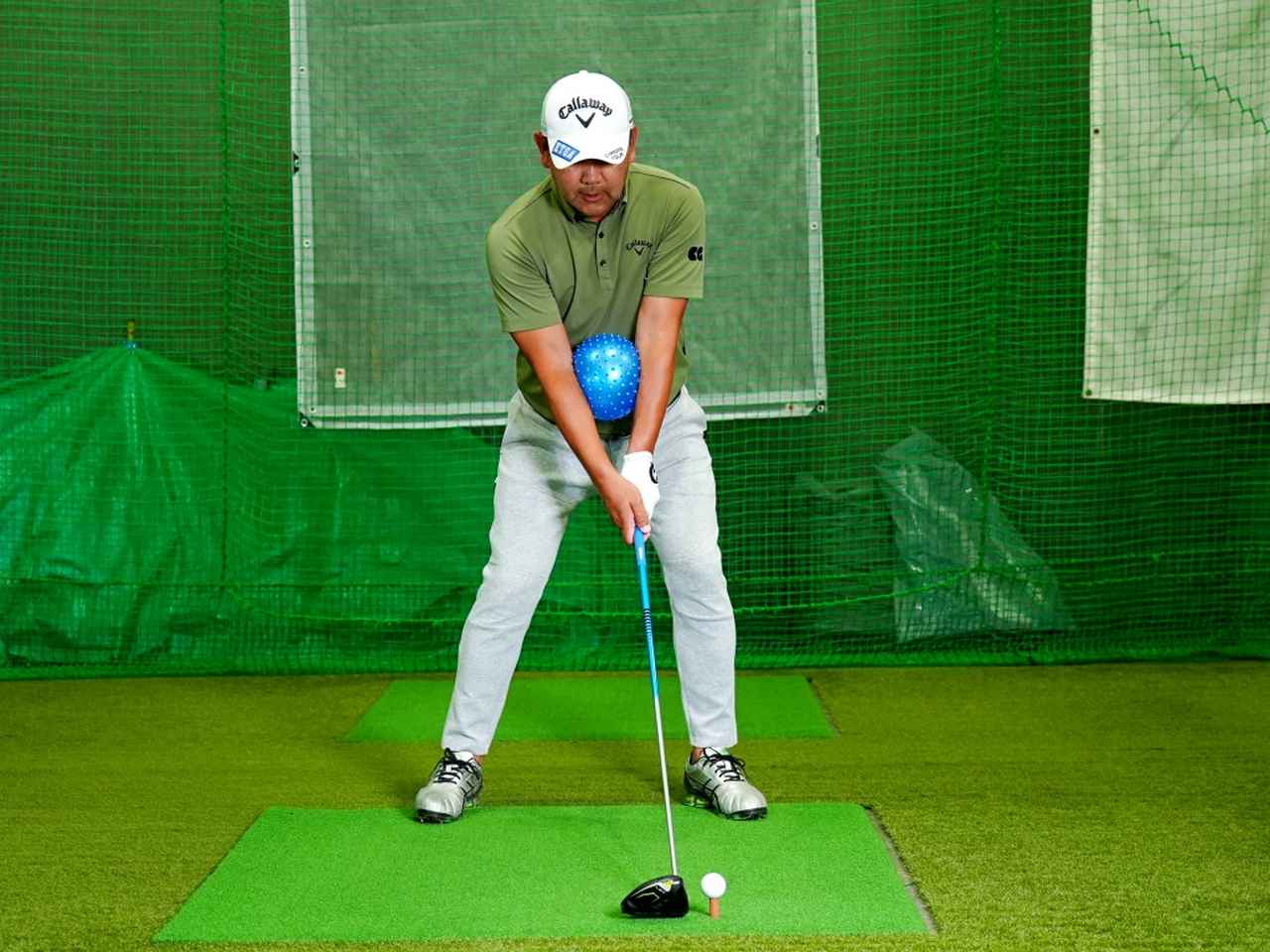 画像: 両腕の前腕にボールを挟んで素振りやショット練習する「ボール挟みドリル」。体と腕を同調させた脱力スウィングが身につく