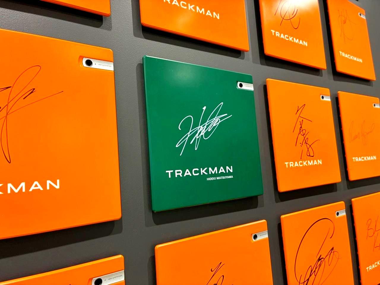 画像: オフィスの壁に飾られたトラックマンを使用する世界中のプロのサイン。グリーントラックマンはマスターズ優勝者だけに贈られる特製。サインは松山英樹
