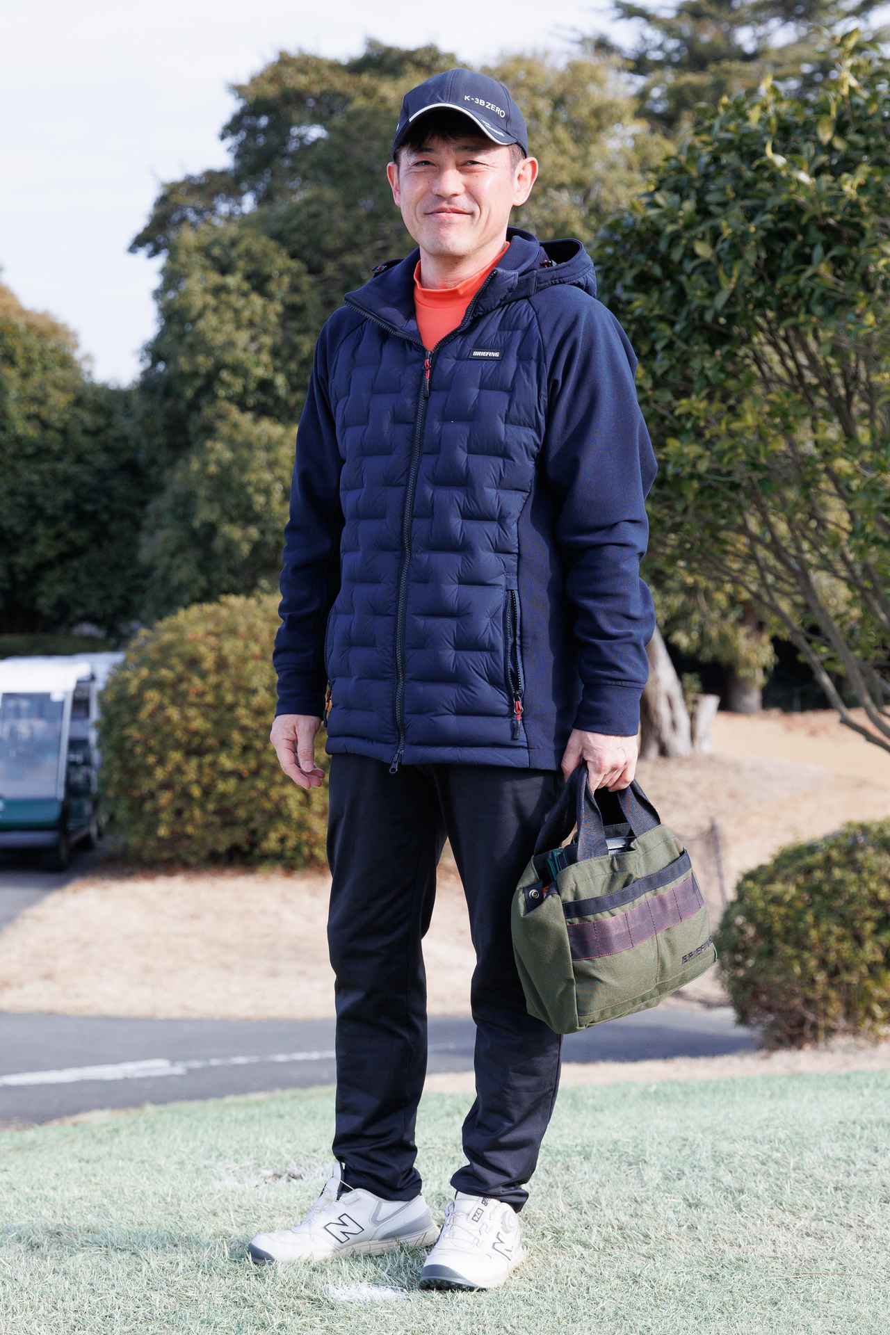 画像: 旬のオーバーサイズのネイビージャケットは部分的に中綿が入っているので動きやすく、保温性も◎。オレンジのモックネックをアクセントにしているのもテクニカルです