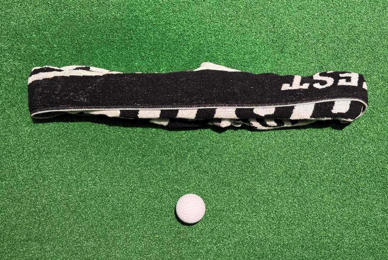 画像: タオルを丸い筒のようにして置いて、これを全部飛ばす感じで打つと、インパクトゾーンのヘッド軌道がシャローになる