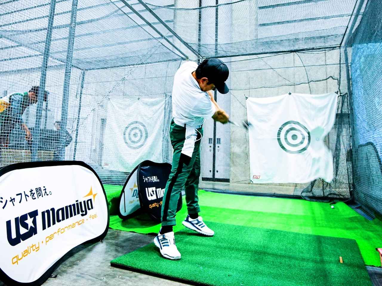 画像: 豪快なショットを放つ松本プロ。打つたびに大きな打席マットがずれる