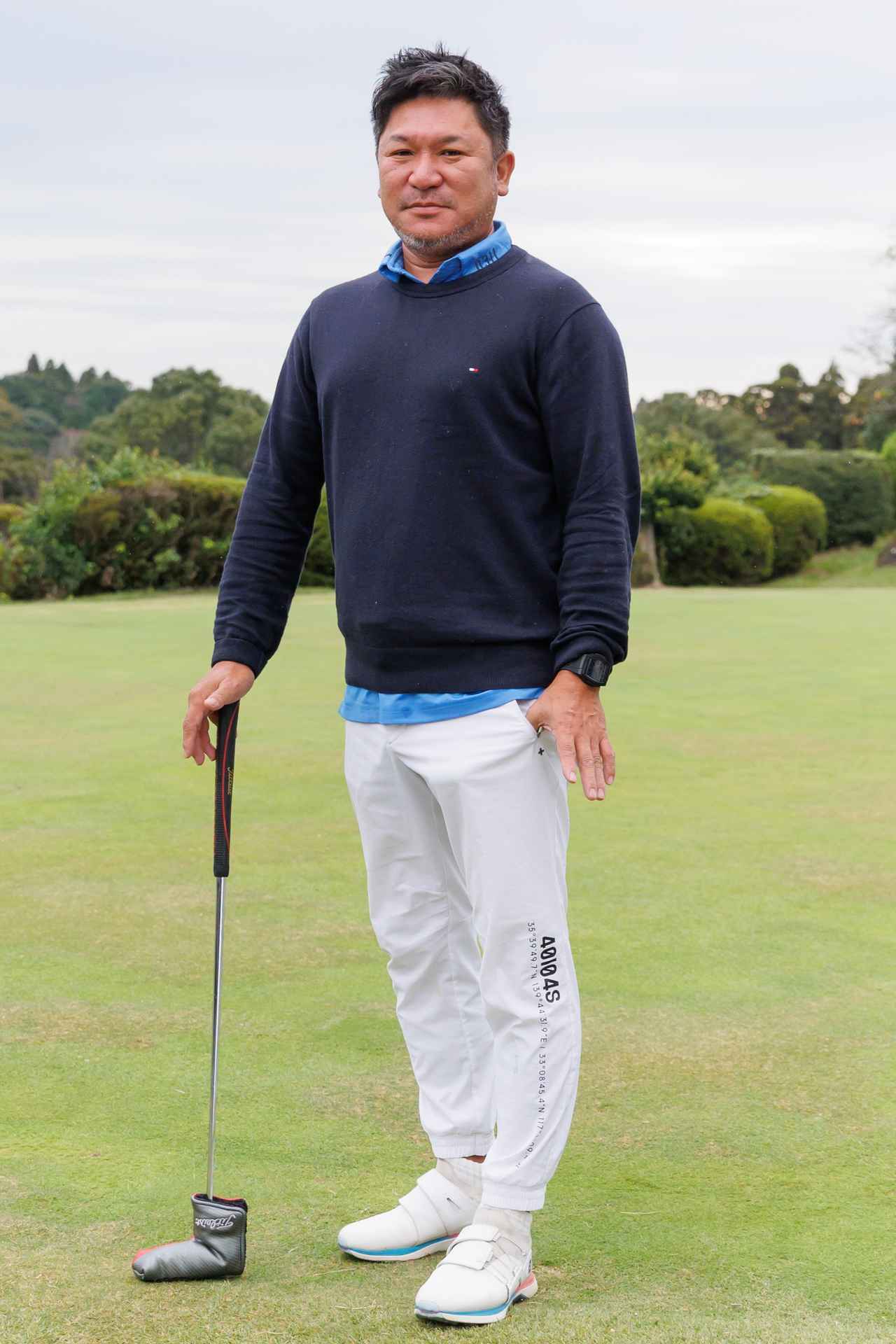 画像: シンプルなクルーネックセーターに鮮やかなブルーのポロシャツを合わせたトップスアレンジがお見事。スポーティな白のジョガーパンツが足元をスッキリとシャープに見せます