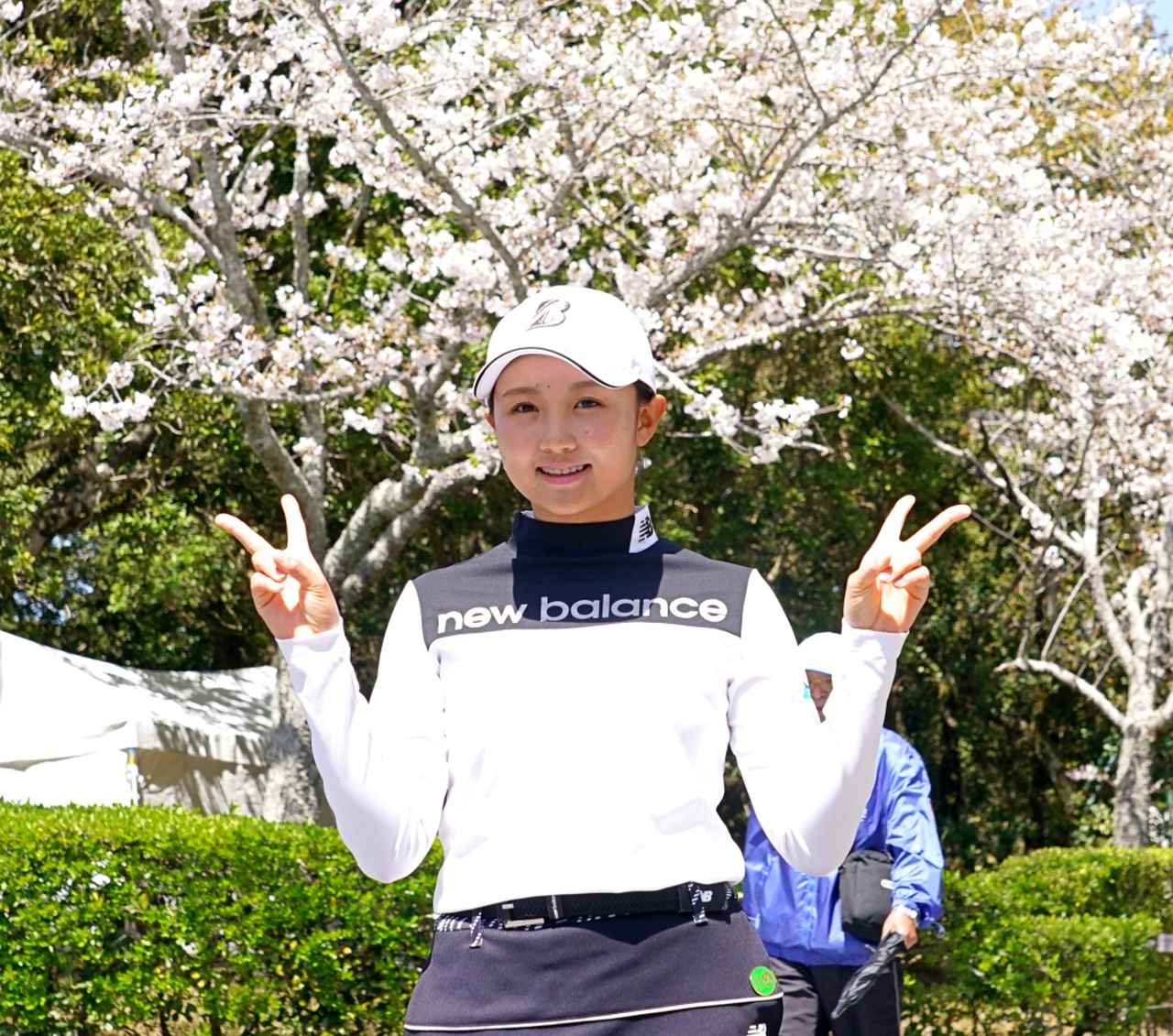 画像: 葛城GCに咲き誇る満開の桜をバックに笑顔を見せる伊藤愛華