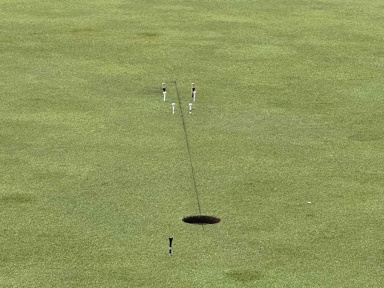 画像: 国内ツアーでは許されていないが、スタート前の練習グリーンで真っすぐのラインに直接線を引いて練習していた