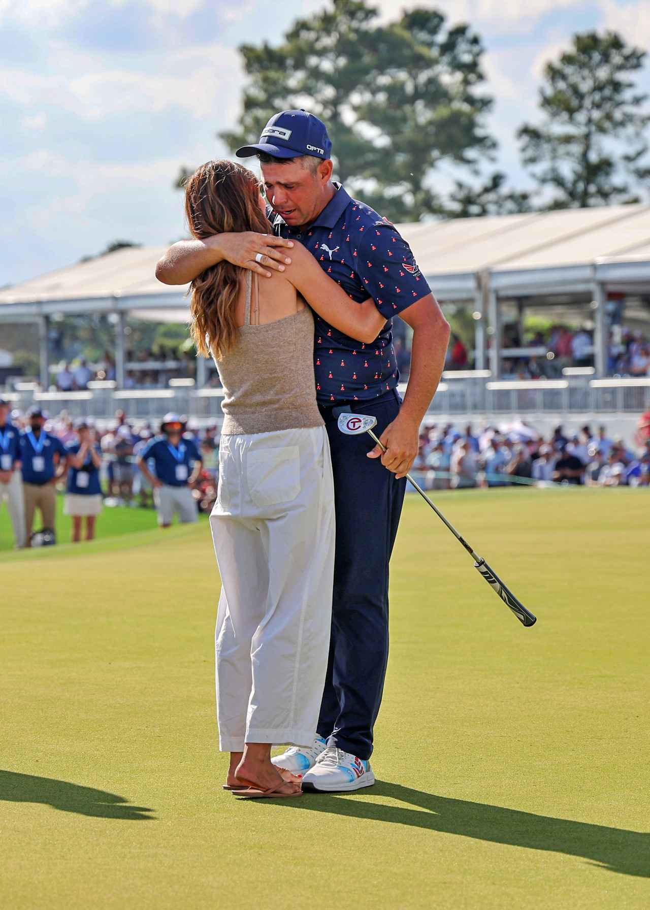 画像: テキサスチルドレンズ・ヒューストンオープンで7年ぶりの復活優勝を決め、18番グリーン上で妻のギャビーさんと抱き合うゲーリー・ウッドランド。3人の子供たちは自宅で待っていたが、ギャビーさんは18ホールずっと彼に付いて歩き、復活の瞬間を見届けたという