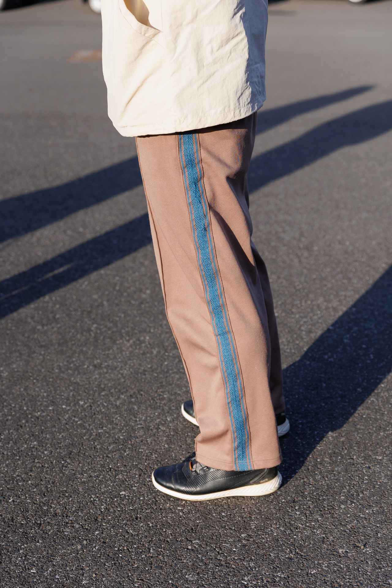 画像: アバンギャルドなブルー系の側章が映えるブラウンパンツ