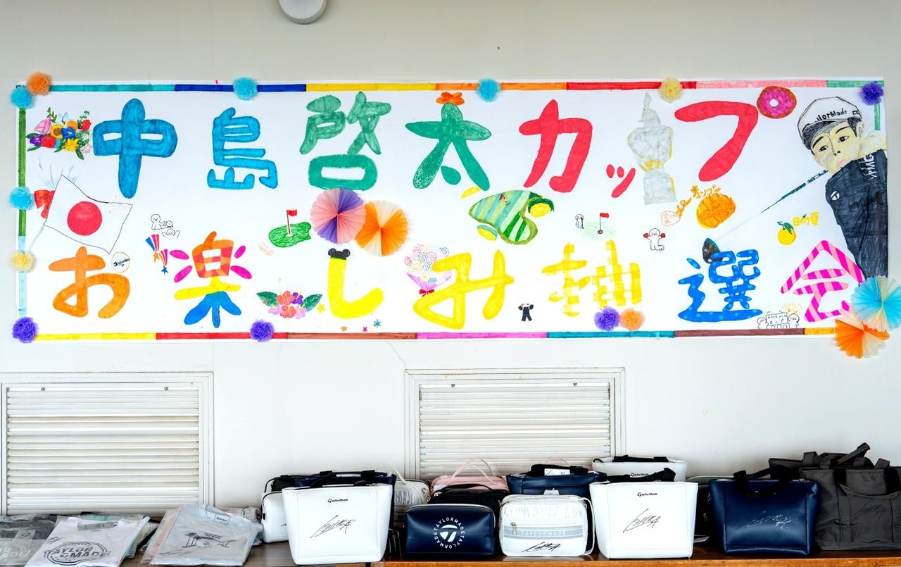 画像1: 美々津CCのクラブハウスに飾ってあった出場ジュニア特製の大会イベントポスターと大会のオフィシャルパネル。競技後のお楽しみ抽選会は出場全員分の景品を用意。すべてに中島啓太プロの直筆サインが入っていた
