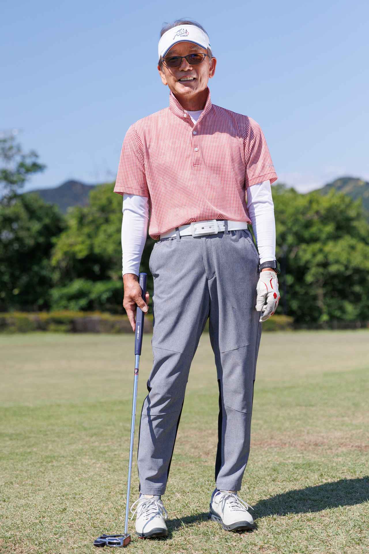 画像: ドット柄が冴えるモダンなレッドポロに、軽快でスポーティなグレーのストレッチパンツが好相性。他は白の小物にすることでトップスとボトムスの存在感を引き立てています