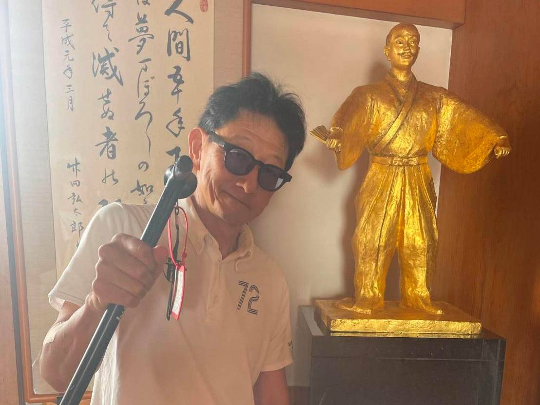 画像: 織田信長像と一緒に写真を撮る三宅さん