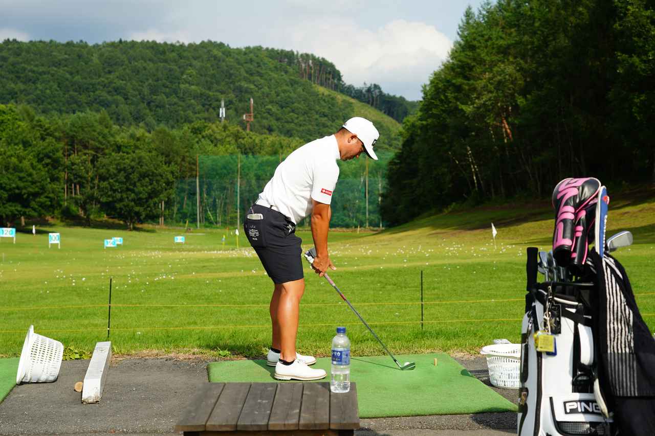 画像: 練習場にてアイアンショットを練習している蟬川