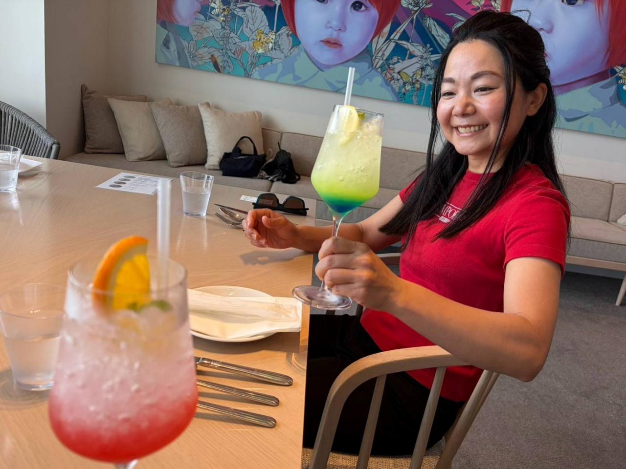 画像: 沖縄の海色のソーダで喜ぶ彩子。「ミーティングで。シークワーサー色の飲み物を選びました。素敵ですよね~」