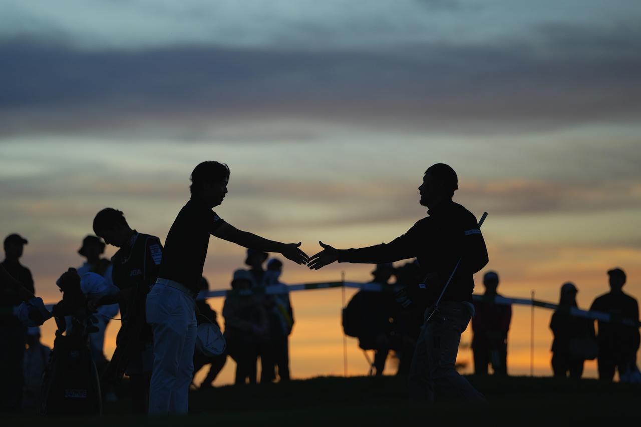 画像: 夕暮れにホールアウトした細野勇策(左)と岩田寛(右)(写真/姉崎正)