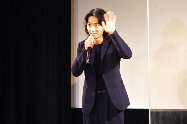 画像: リモート中継でつながっている観客へ手を振る山﨑賢人