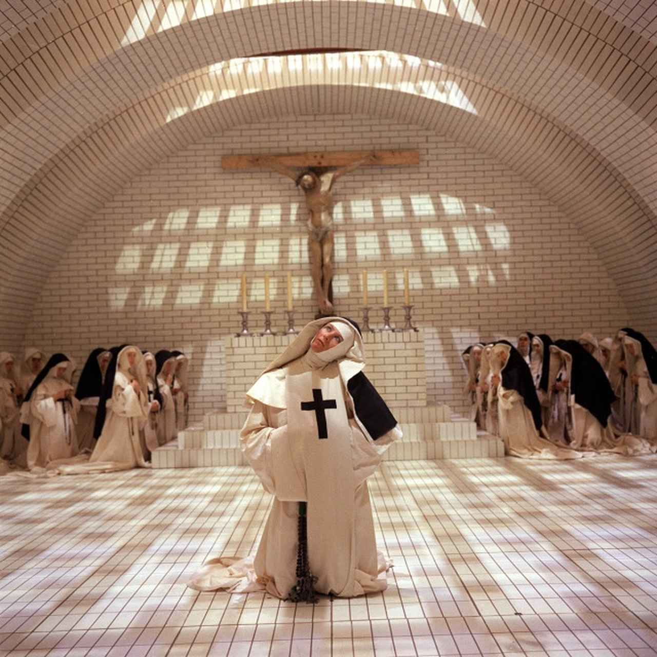 画像: 『肉体の悪魔』の修道院。中央にいるのが、シスター・ジャンヌ役のヴァネッサ・レッドグレイヴ。英国を代表する名女優のひとりで、『裸足のイサドラ』で2度目のカンヌ映画祭主演女優賞受賞、『ジュリア』ではオスカー受賞。『ミッション:インポッシブル』や『つぐない』などにも出演。モノトーンのグラフィックなデザインは後に『カラヴァッジオ』を監督のデレク・ジャーマン。