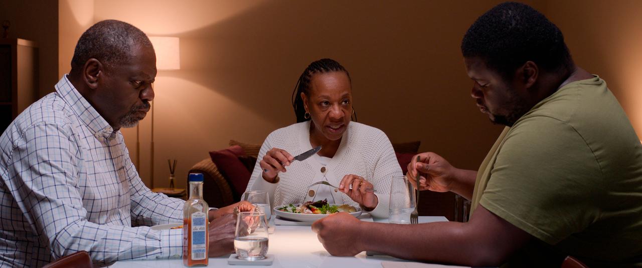 画像: 食事中に働き者の夫(左)や息子(右)にも小言をいうパンジー(中央) ©Untitled 23 / Channel Four Television Corporation / Mediapro Cine S.L.U.