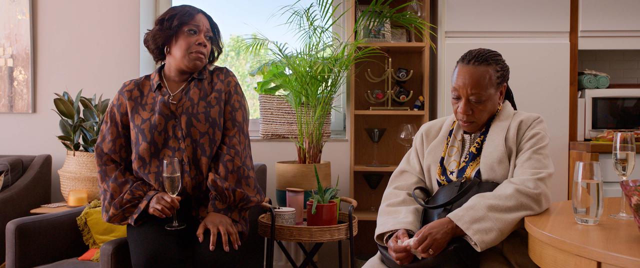 画像: 美容師の妹、シャンテル(ミシェル・オースティン)と姉のパンジー(マリアンヌ・ジャン=バプティスト)。墓参りに行った後、ふたりは過去の出来事を振り返る。 ©Untitled 23 / Channel Four Television Corporation / Mediapro Cine S.L.U.