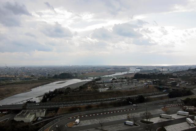 画像: 手前が東名高速、左奥が富士市街、右奥に駿河湾が光っている。