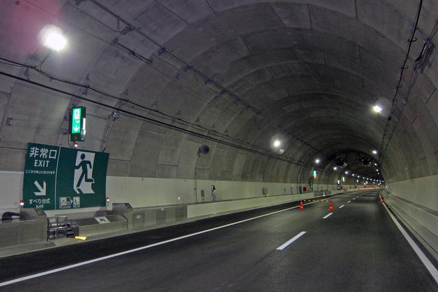 画像: シールド工法で造られたトンネルの内部。路面幅は9.75m。写真左側の非常口がすべり台方式のもの。