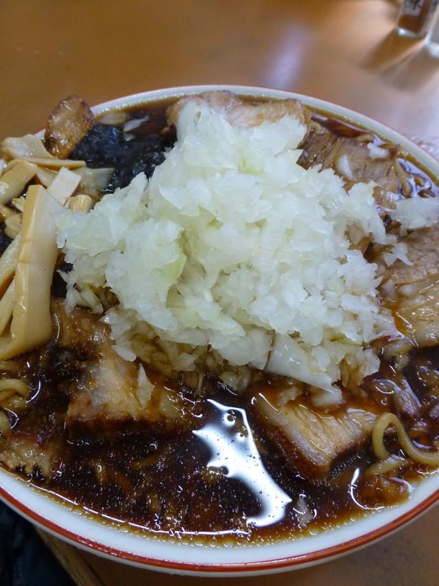 画像: 溢れんばかりの黒いスープ(てか、本当に溢れてテーブルにスープがこぼれている)が特徴。チャーシューメンは肉が8枚、ふつうのラーメンは4枚入っている。