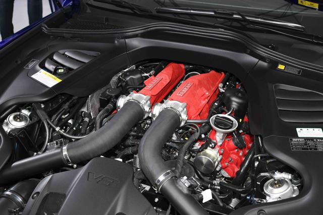 画像: フロントボンネット下に搭載される3.9L V型8気筒ツインターボエンジン。6.3L V型12気筒エンジンでもフロントミッドシップレイアウトを採用されているだけに、V8ツインターボエンジンはボンネットルーム内のすごい後方に位置しているように見える。赤い結晶塗装が施されたヘッドカバーとインテークマニフォールドも含めて、エンジンルーム内も凝ったデザインが採用されている。