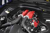 画像: フロントボンネット下に搭載される3.9L V型8気筒ツインターボエンジン。6.3L V型12気筒エンジンでもフロントミッドシップレイアウトを採用されているだけに、V8ツインターボエンジンはボンネットルーム内のすごい後方に位置しているように見える。赤い結晶塗装が施されたヘッドカバーとインテークマニフォールドも含めて、エンジンルーム内も凝ったデザインが採用されている。