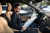 画像: 自動運転レベル3では、走行中にステアリングから手を離して新聞や雑誌を読んでもOKになる