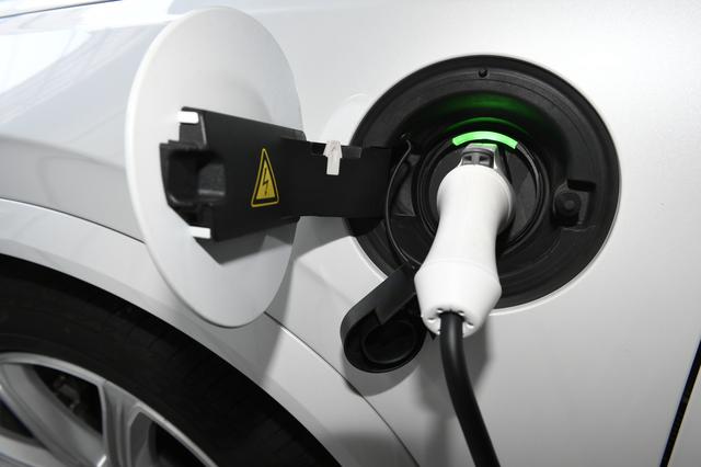 画像: 付属のケーブルで充電。クルマをロックするとケーブルも抜けないように固定される。充電の状況は充電口の色によりわかる。