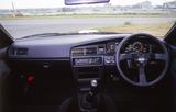 画像: 写真はNISMOオプションの3本スポークステアリングを装着した状態。ノーマルでは、ステアリングは商用車のような2本スポークのPPステアリング、内装も快適装備はほとんど外されて軽量化が図られていた。