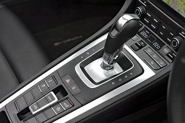 画像: 7速PDKはパドルシフトも備わる。シフト手前には、サスペンションやリアスポイラーの調節スイッチなどが並ぶ。
