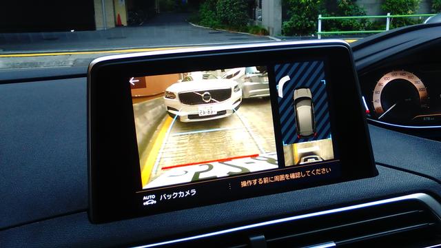画像: バックで縦列に駐車。カメラの視界は広めで、背後の車両とともに周囲を確認することができる